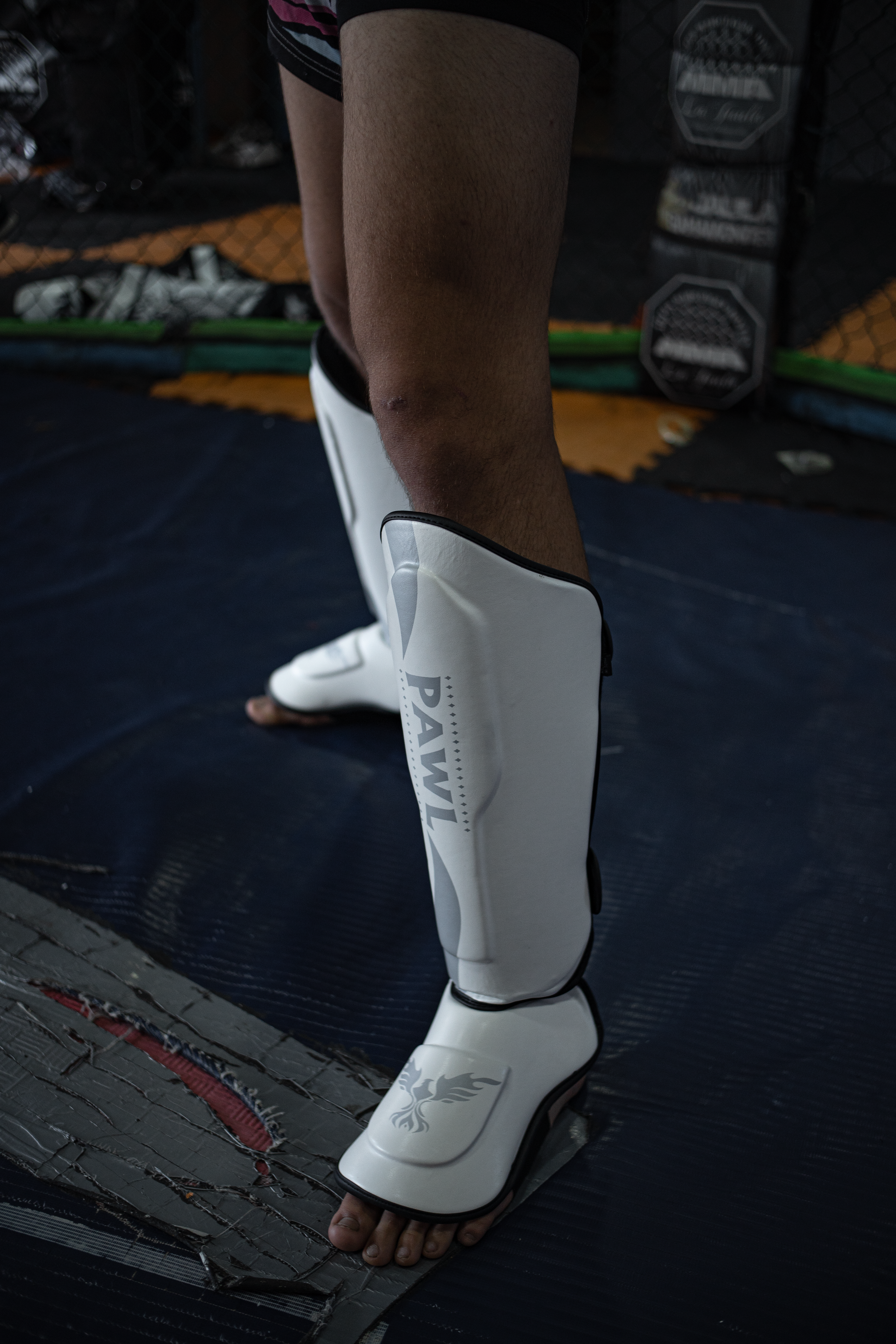 Canilleras MMA blancas en uso durante entrenamiento de sparring