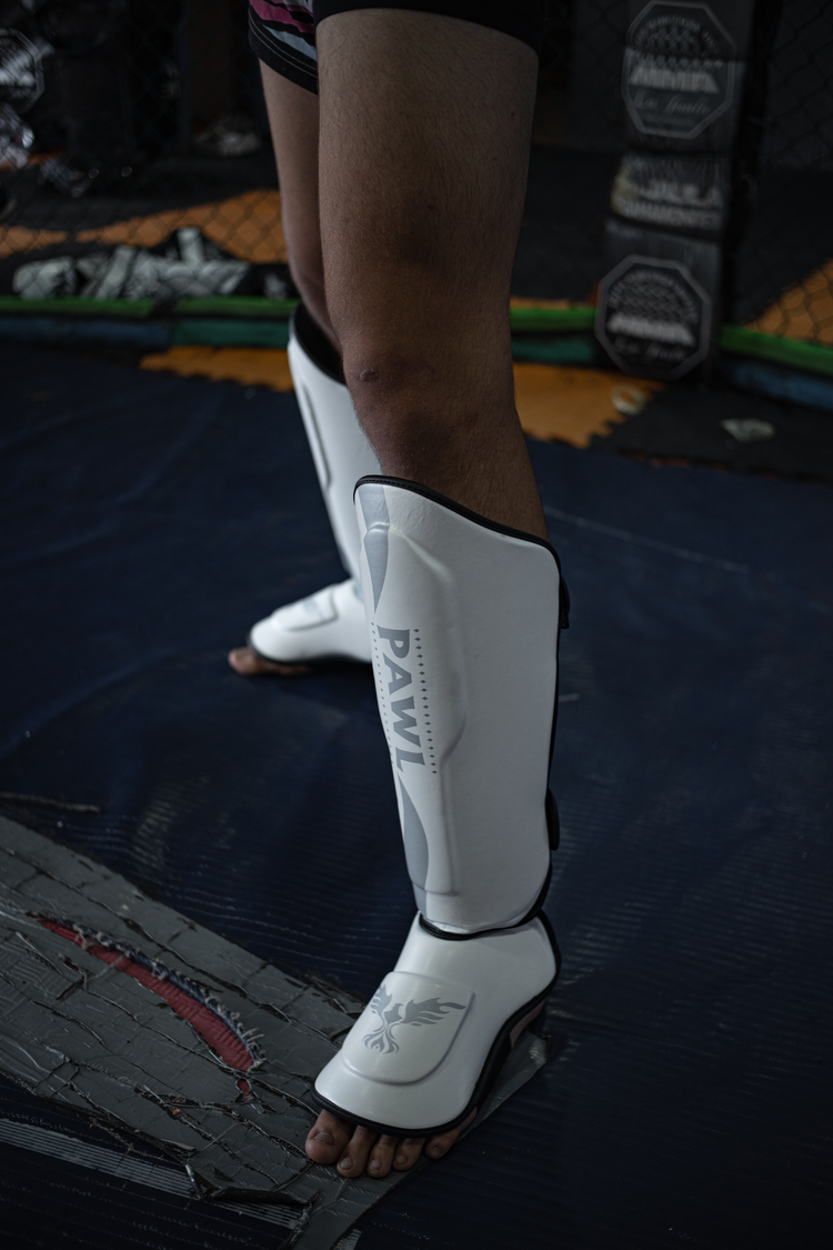 Canilleras MMA blancas en uso durante entrenamiento de sparring