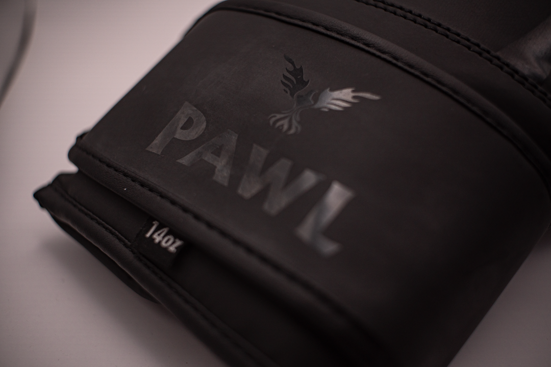Detalle de guantes de boxeo negros PAWL con acabado premium