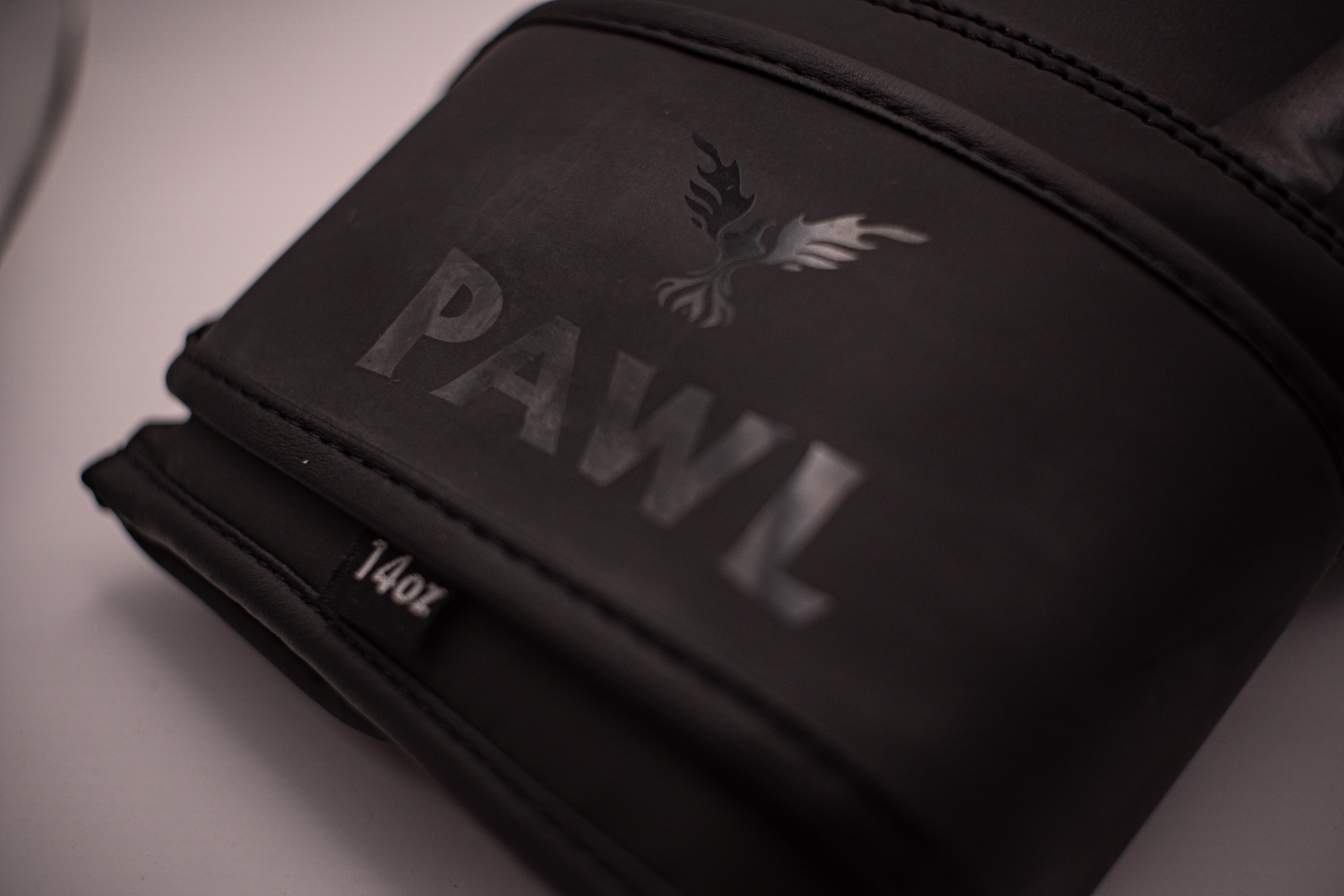 Detalle de guantes de boxeo negros PAWL con acabado premium