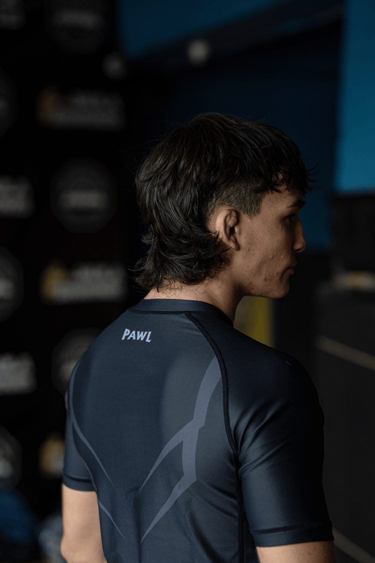 ista lateral de modelo usando rashguard Hero gris para entrenamiento de BJJ y MMA en Chile.