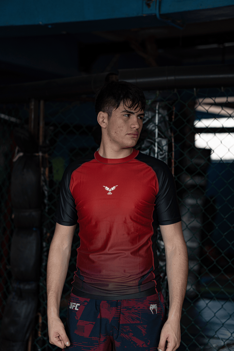 Rashguard Hero roja en modelo, ideal para No-Gi, grappling y MMA, ropa deportiva premium en Chile.
