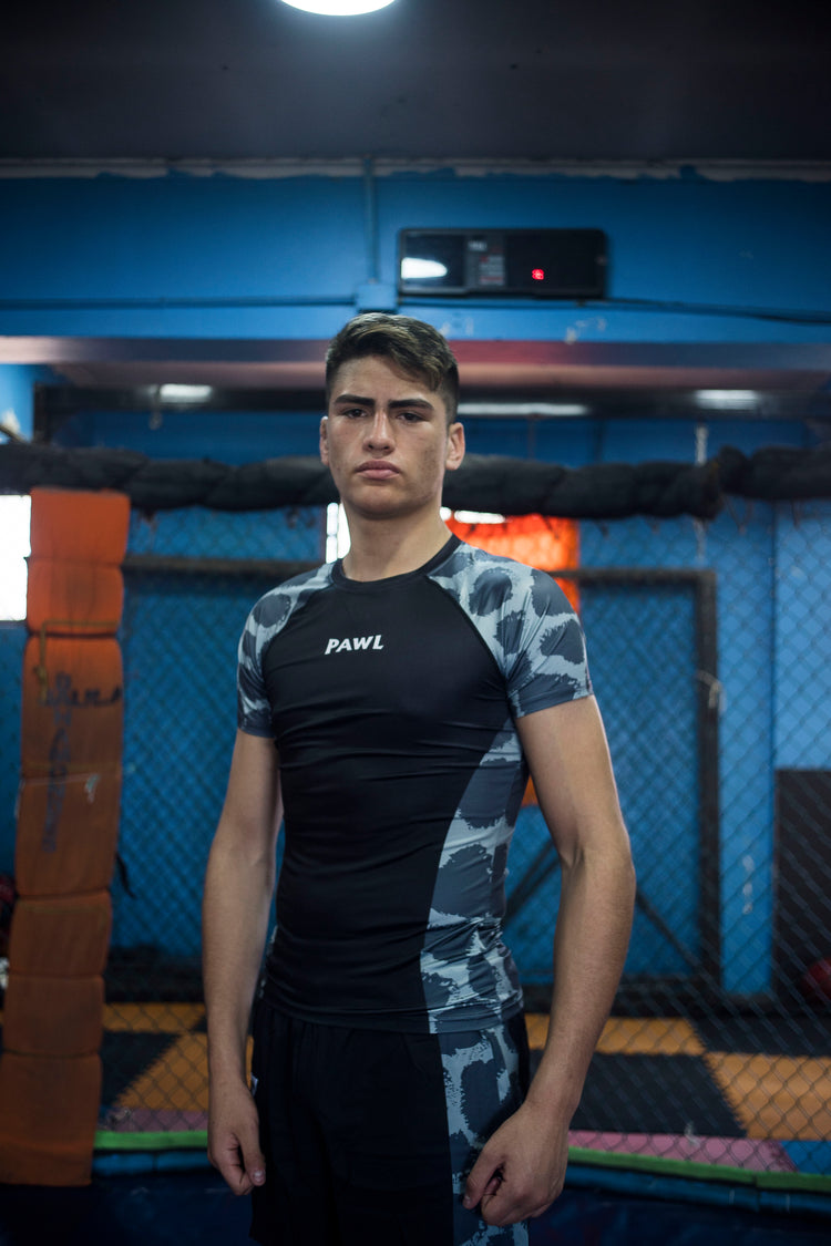 Modelo usando rashguard negra premium para entrenamiento de MMA, BJJ y grappling en Chile